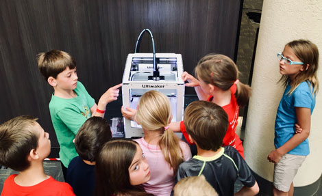Barn som studerar en 3D-skrivare. Foto: Adam Winger